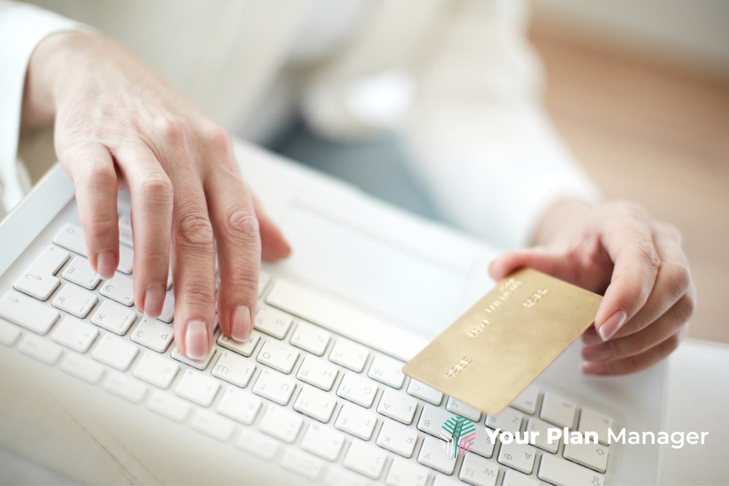 woman typing on keyboard with a credit card in one hand about to make a purchase.